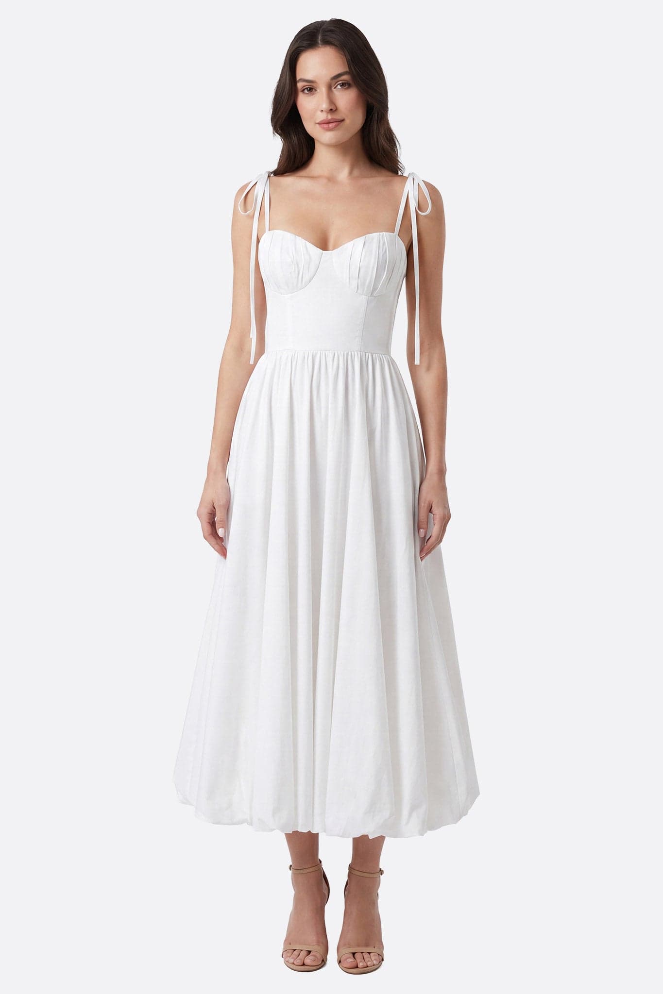 Mannequin de face portant une robe midi blanche à bretelles nouées, bustier plissé, jupe ample