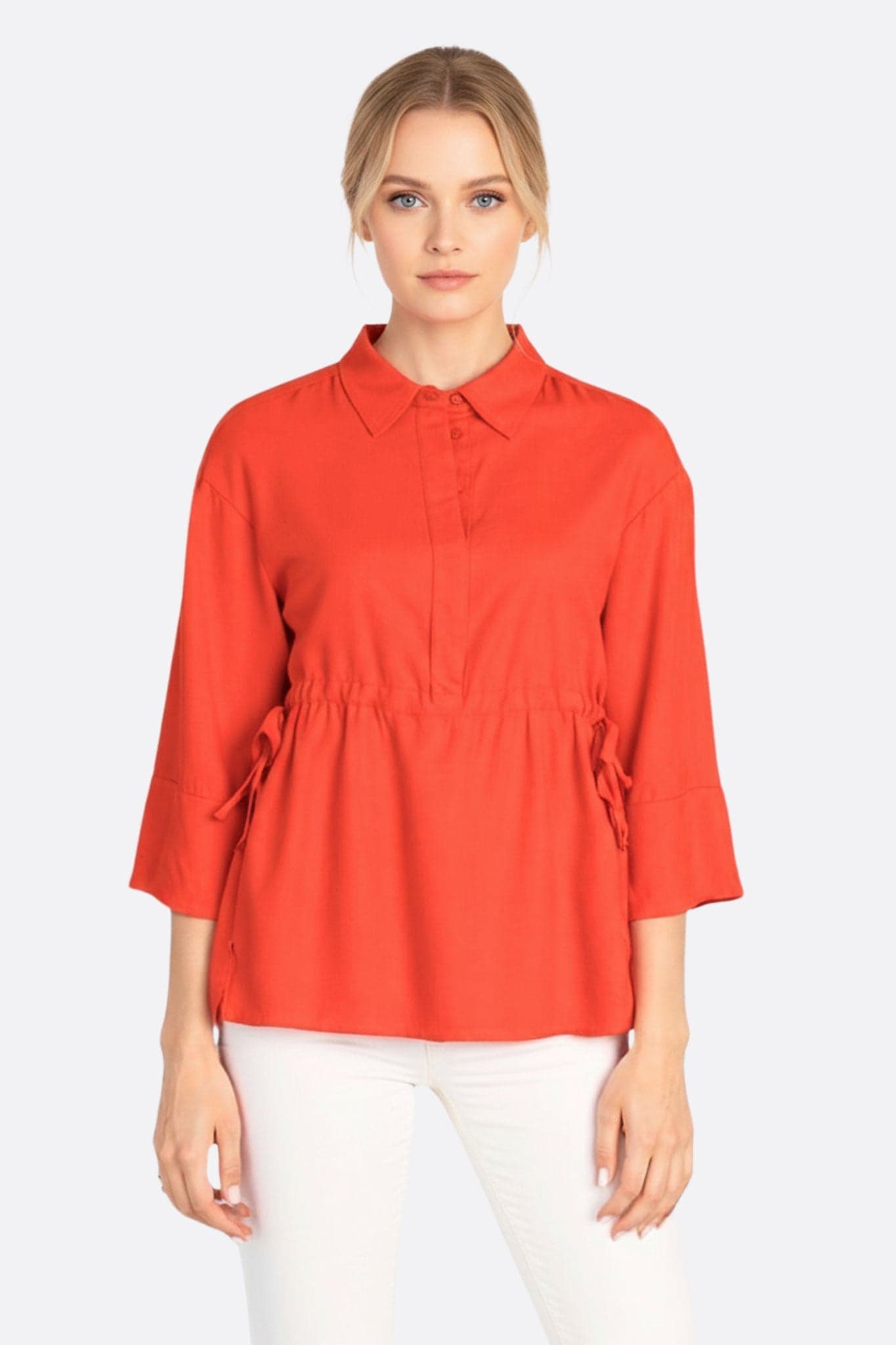 Blouse en lin rouge corail, à l'aspect fluide et aux liens ajustables, parfaite pour une allure décontractée et raffinée.