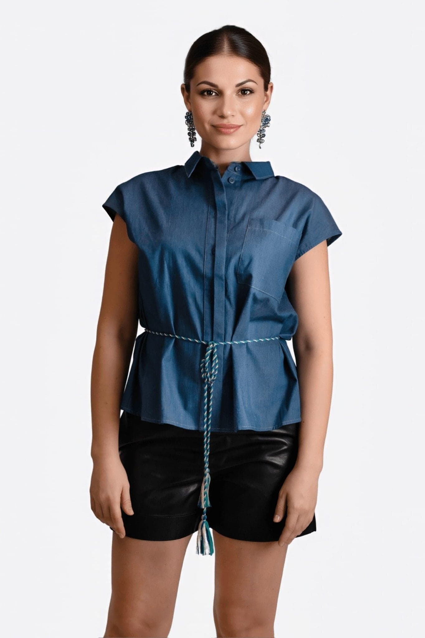 Blouse sans manches en denim bleu, col chemise classique, chic et moderne, idéale pour une tenue décontractée.