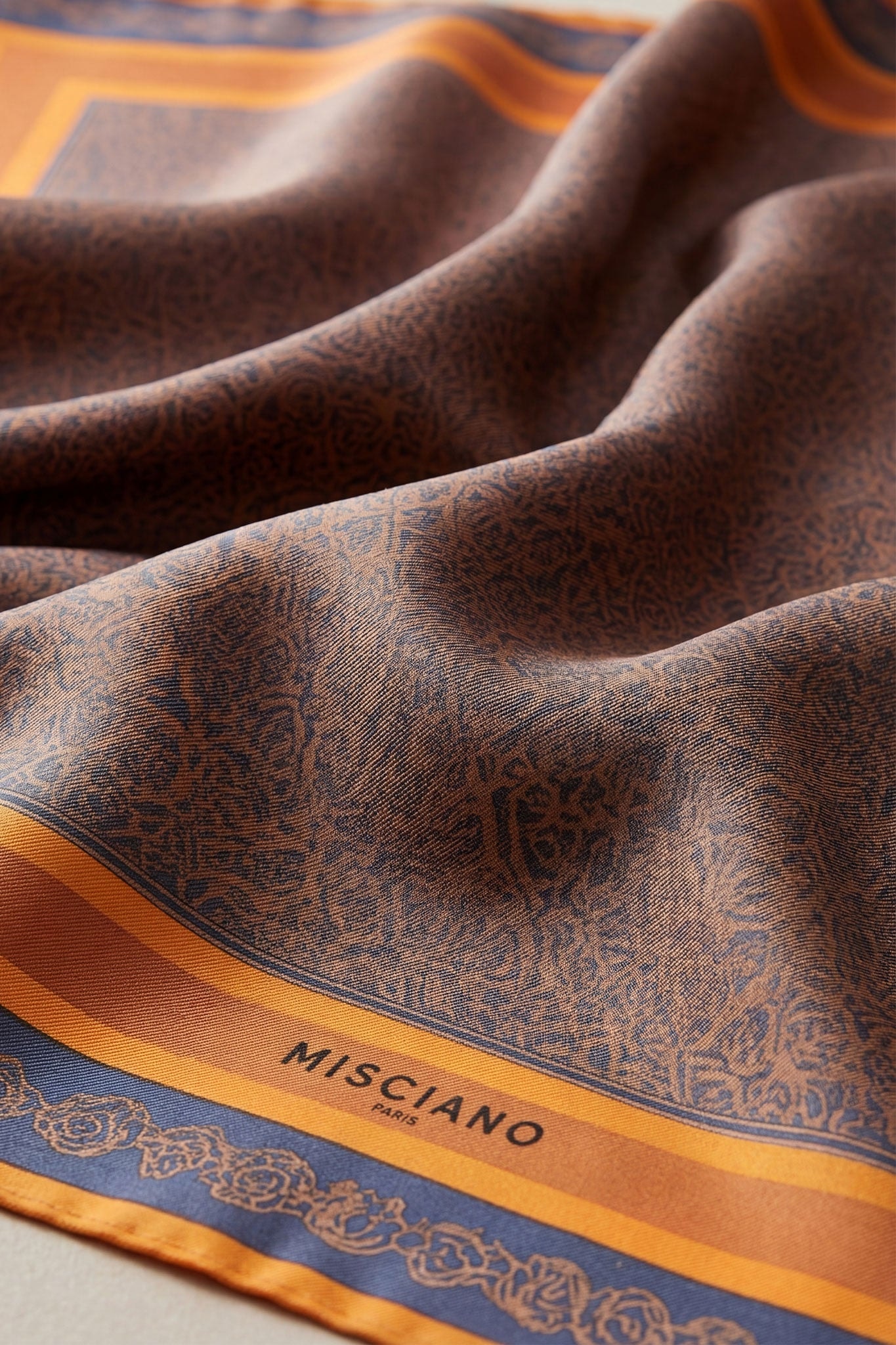 Détail élégant du carré en soie 90 cm, imprimé double face avec motifs Ombres d'orient, idéal pour accessoiriser une...