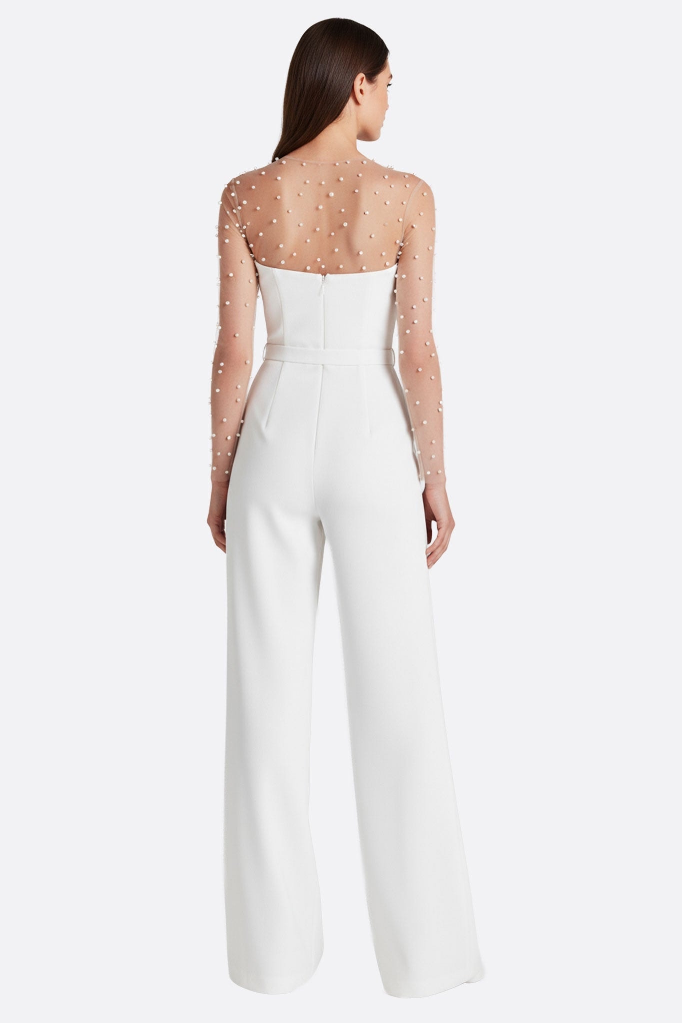 Angular detail of the white strapless jumpsuit with illusion beaded sleeves, a chic choice for a stylish wedding and...