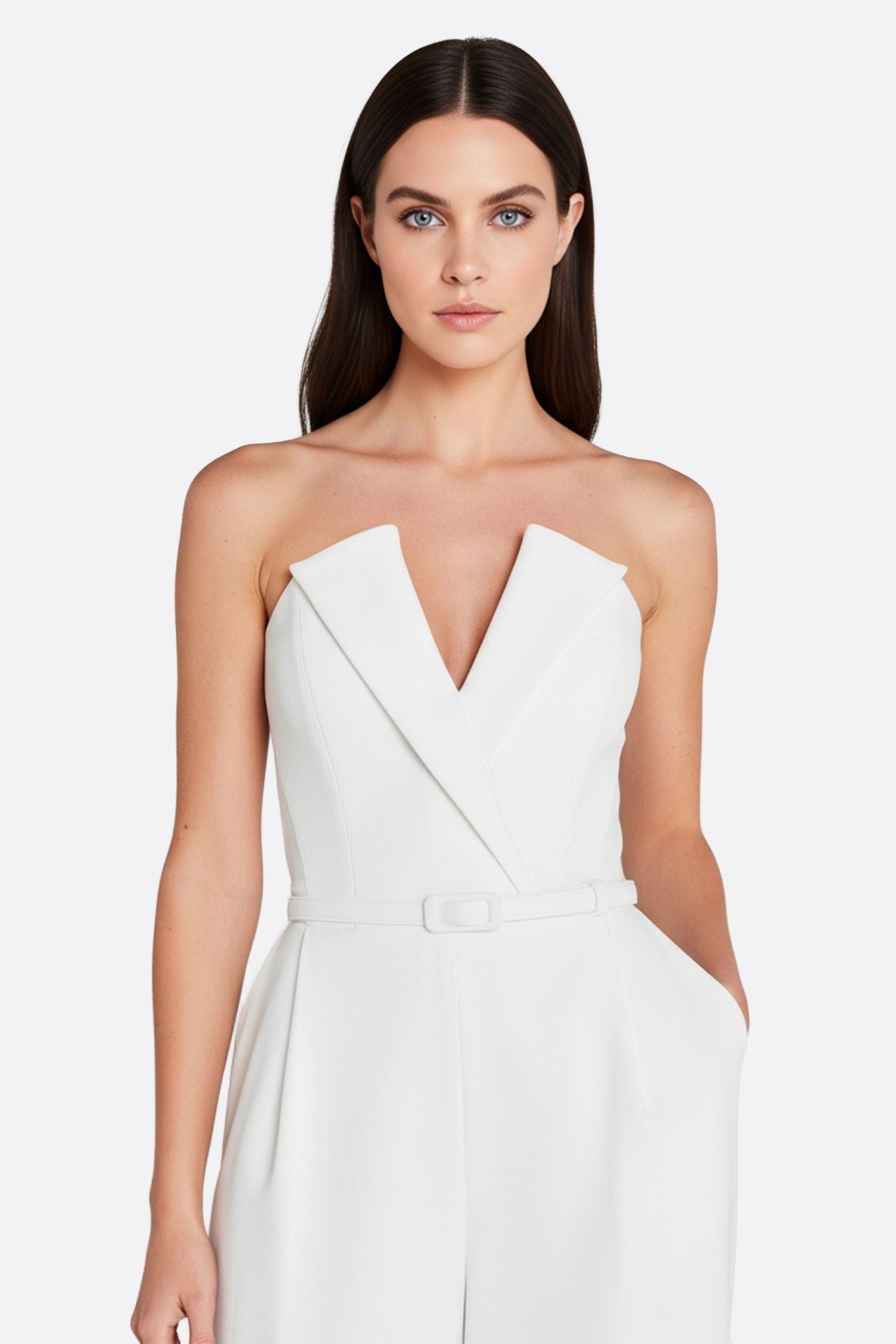 Close-up on the illusion beaded sleeves of the white strapless jumpsuit, a refined piece for an elegant wedding and...