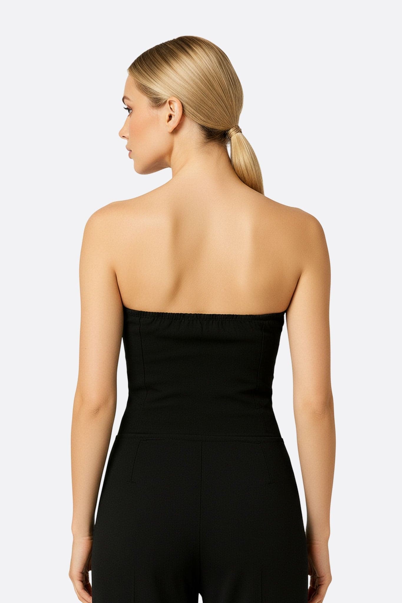 Vue 3/4 de la combinaison noire bustier à coupe évasée, mettant en lumière son allure chic et son style contemporain,...