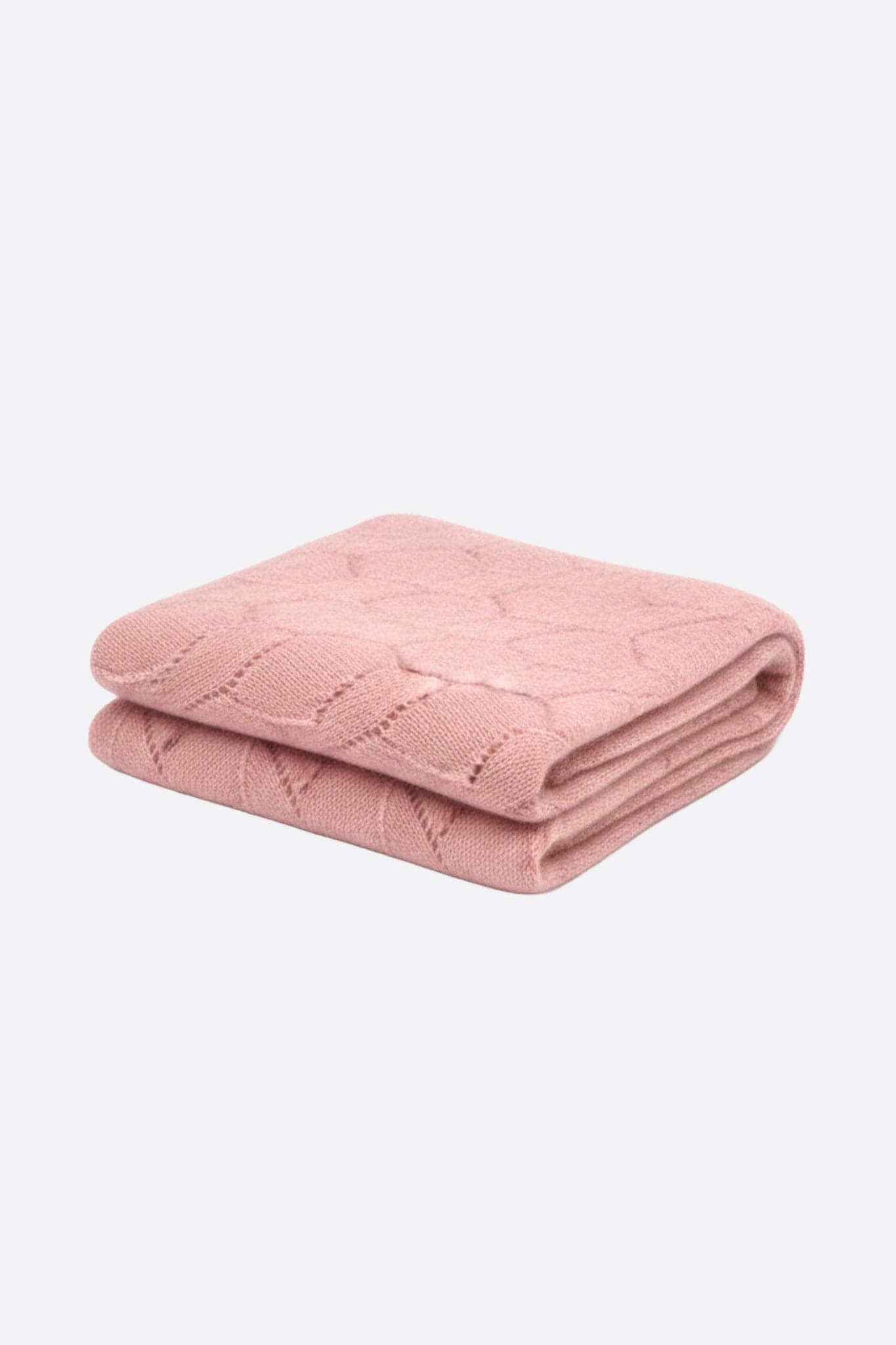 Détail d'une écharpe en cachemire rose poudré, mettant en avant sa maille ajourée délicate, parfaite pour les soirées...