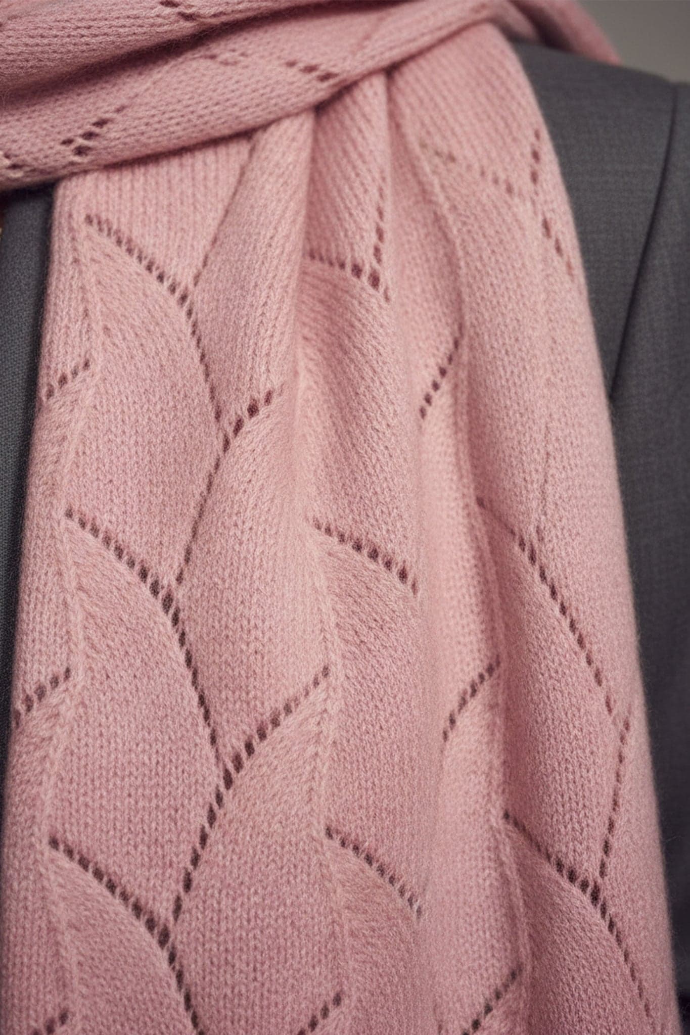 Écharpe en cachemire rose clair à maille ajourée, vue 3/4 illustrant son élégance légère et son allure romantique.