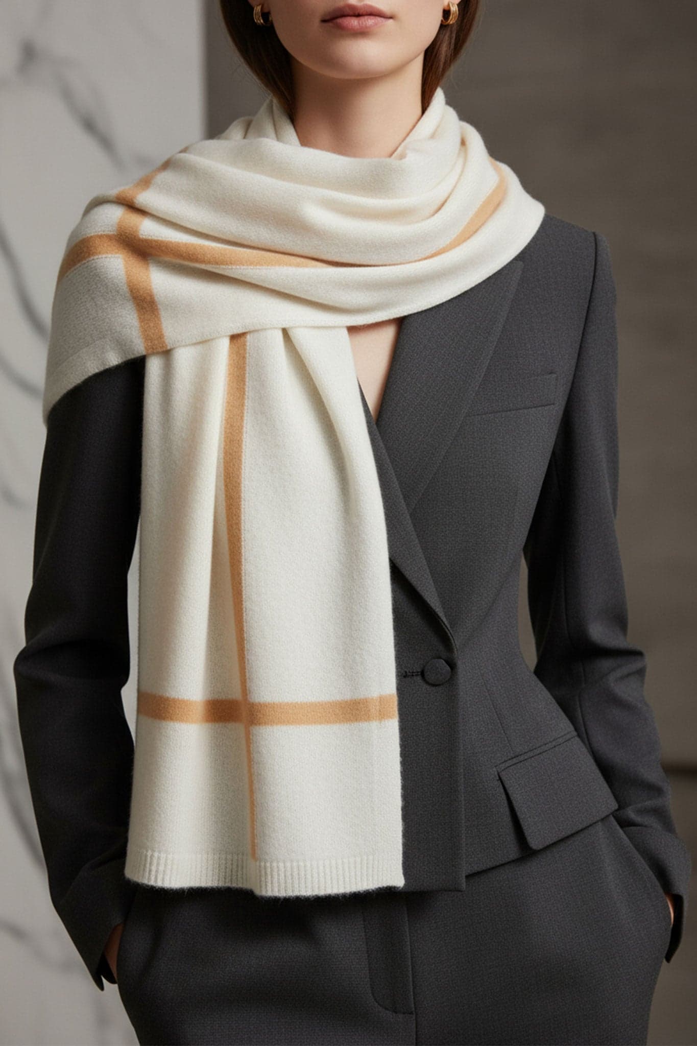 Zoom sur une écharpe en cachemire blanc avec des bandes marron, accessoire chic pour une touche raffinée au quotidien.