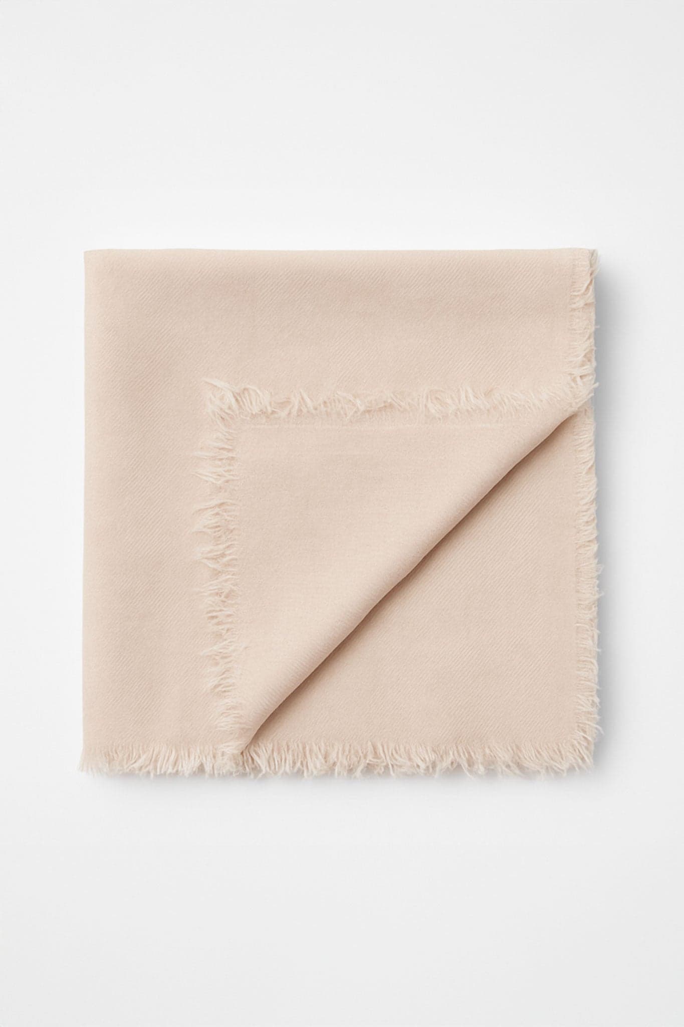 Écharpe en rose poudré, mélange luxueux de modal, laine et cachemire, vue 3/4 révélant son élégance casual et raffinée.