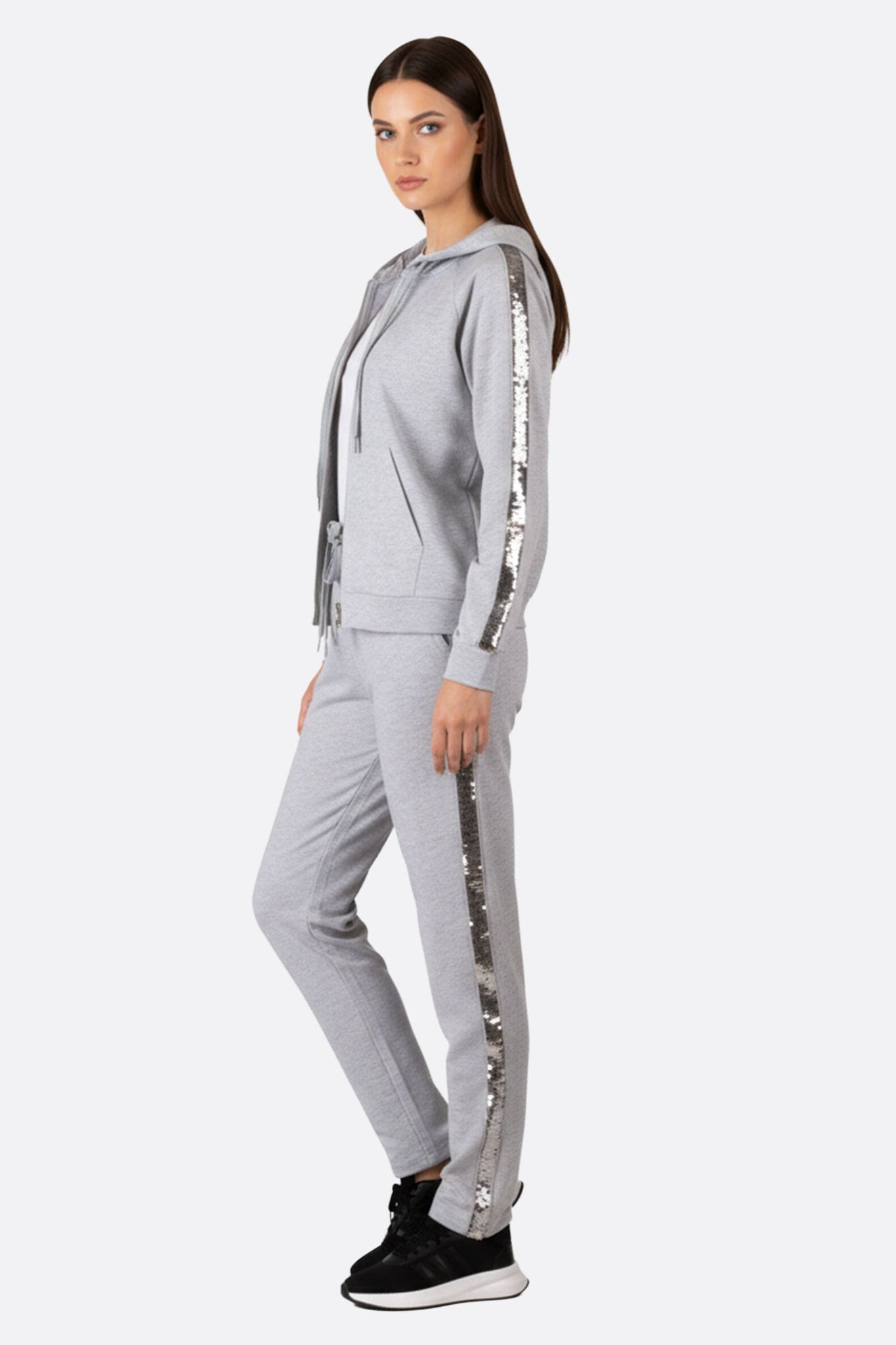 Zoom sur les détails de l'ensemble de survêtement gris perle, avec des bandes de sequins brillants pour une allure...