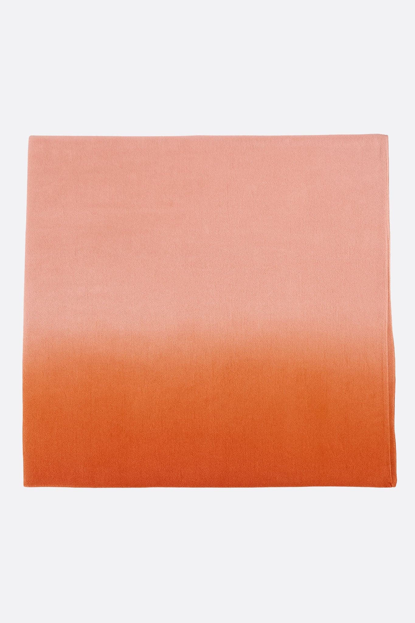 Détail d'une écharpe en soie et coton orange dégradé, alliant élégance et légèreté, idéale pour les soirées raffinées.