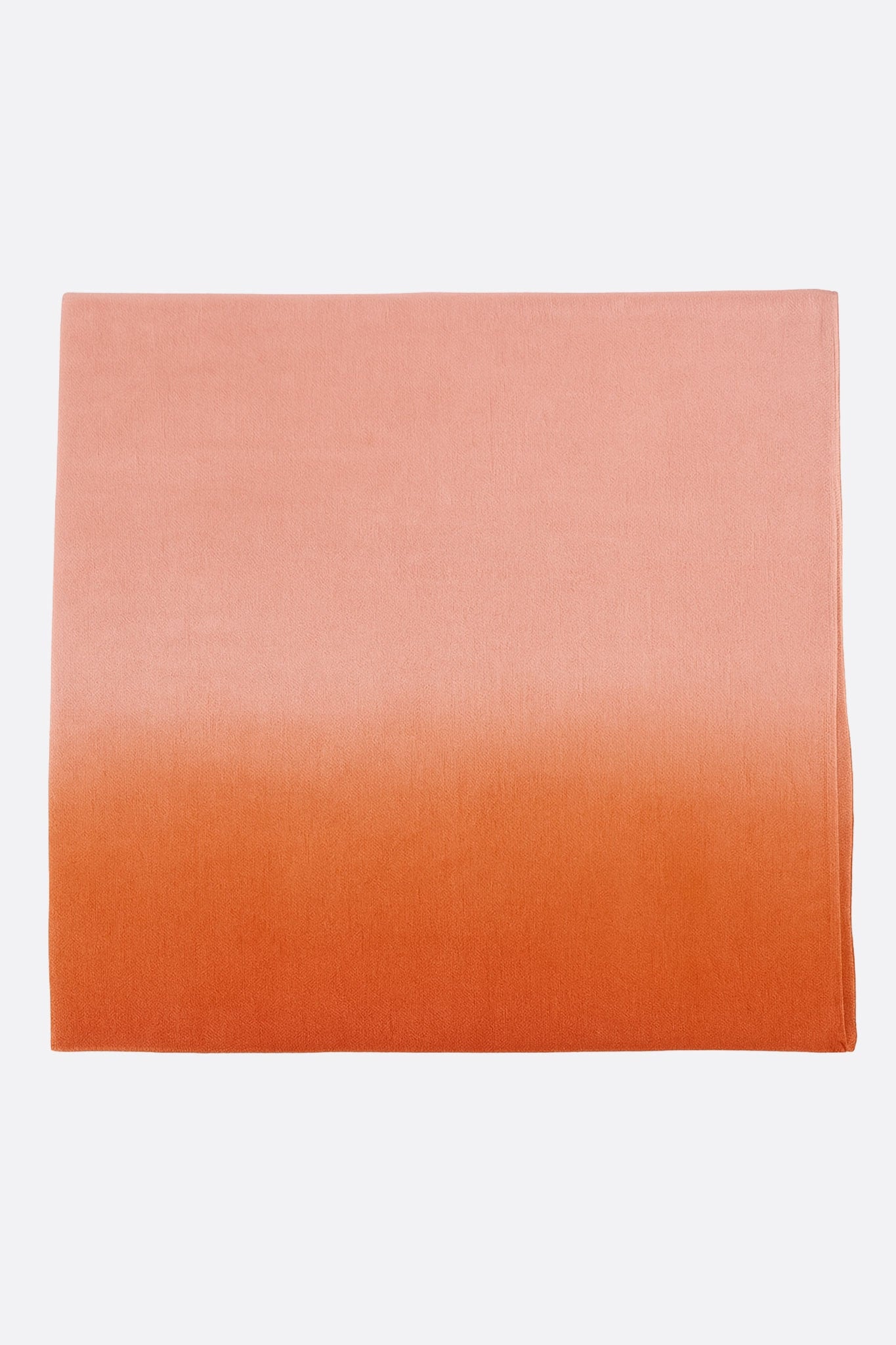Détail d'une écharpe en soie et coton orange dégradé, alliant élégance et légèreté, idéale pour les soirées raffinées.