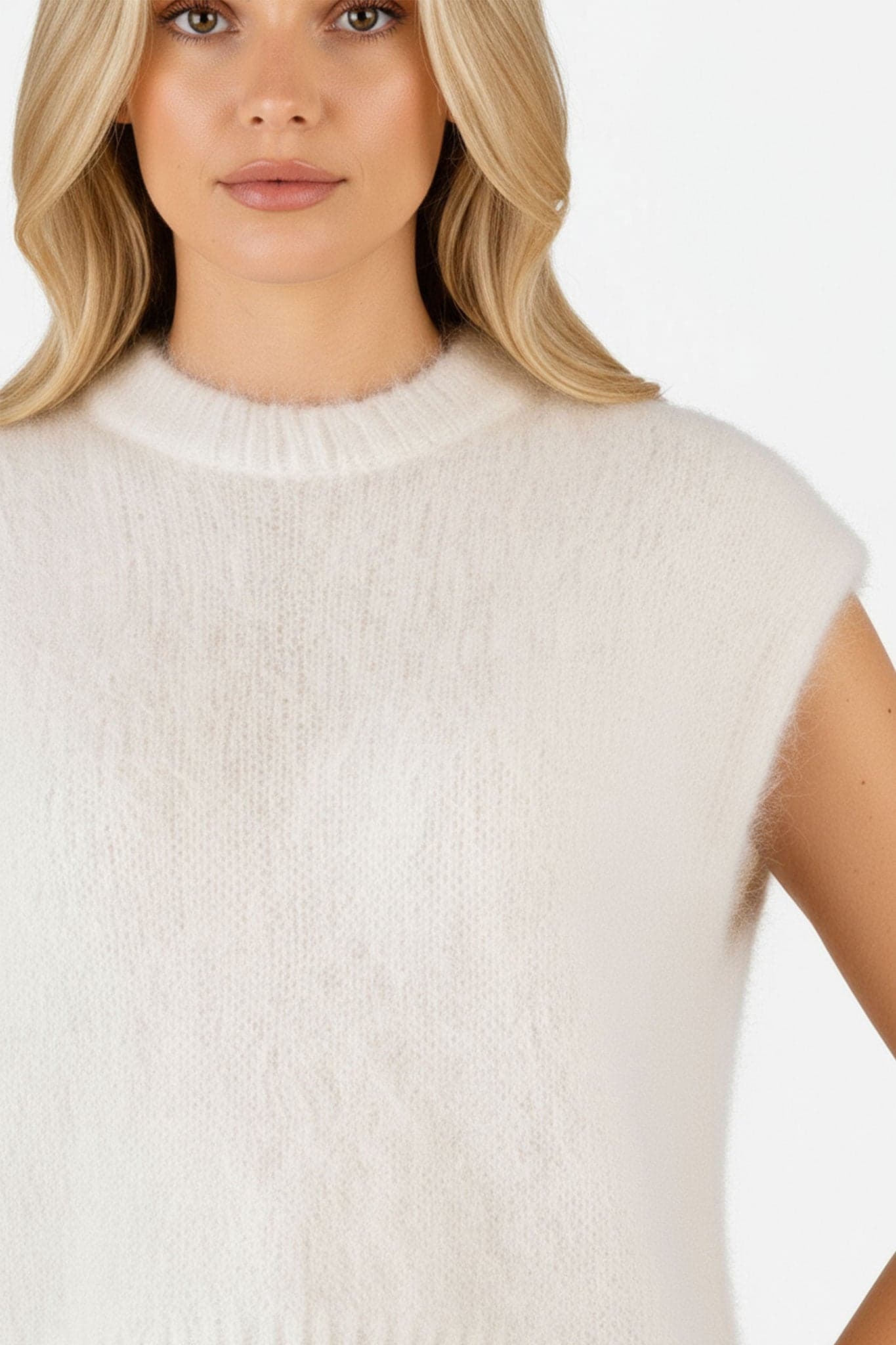 Textura delicada del chaleco sin mangas de mohair blanco, perfecto para un atuendo refinado en eventos elegantes.