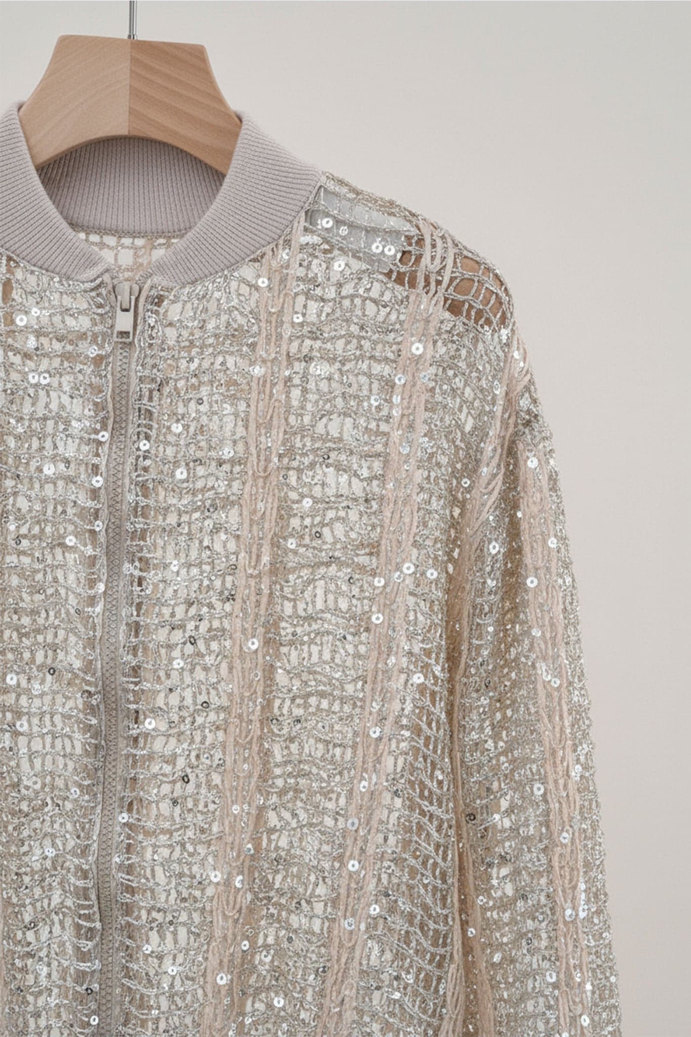 Openwork champagne bomber vest in linen and silk, revealing shiny sequins for a touch of elegance at an evening.