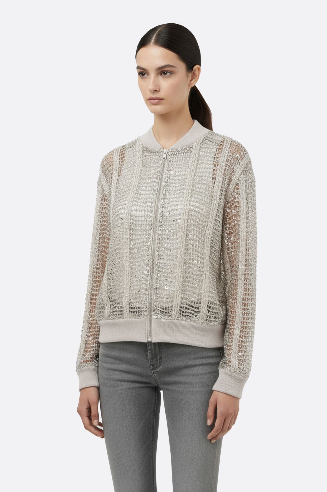 Close-up on the champagne openwork bomber vest in linen and silk, highlighting sparkling sequins for a chic look.