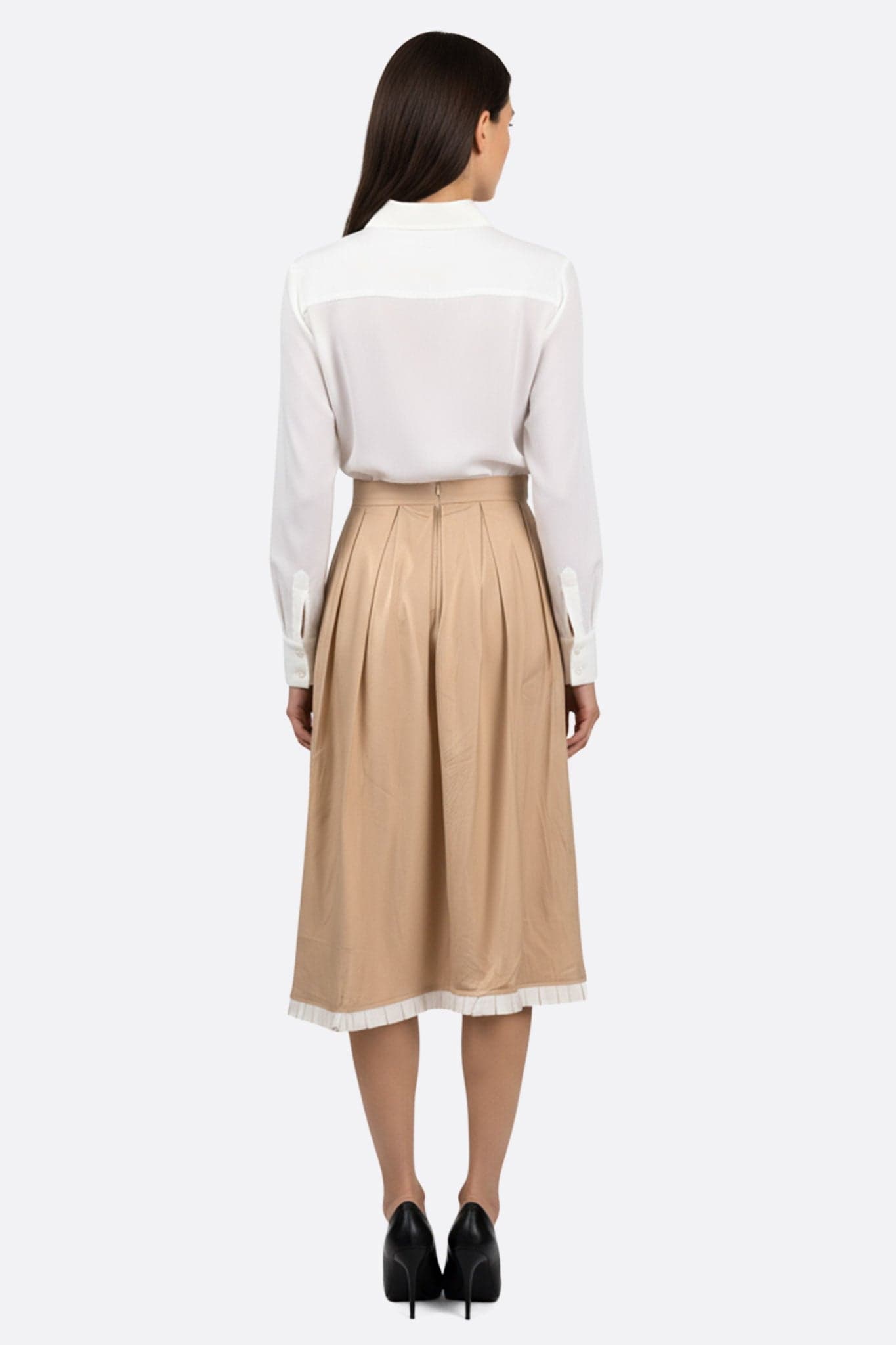 Zoom sur la jupe midi plissée beige avec ses bords contrastants, idéale pour une tenue élégante en toute occasion.