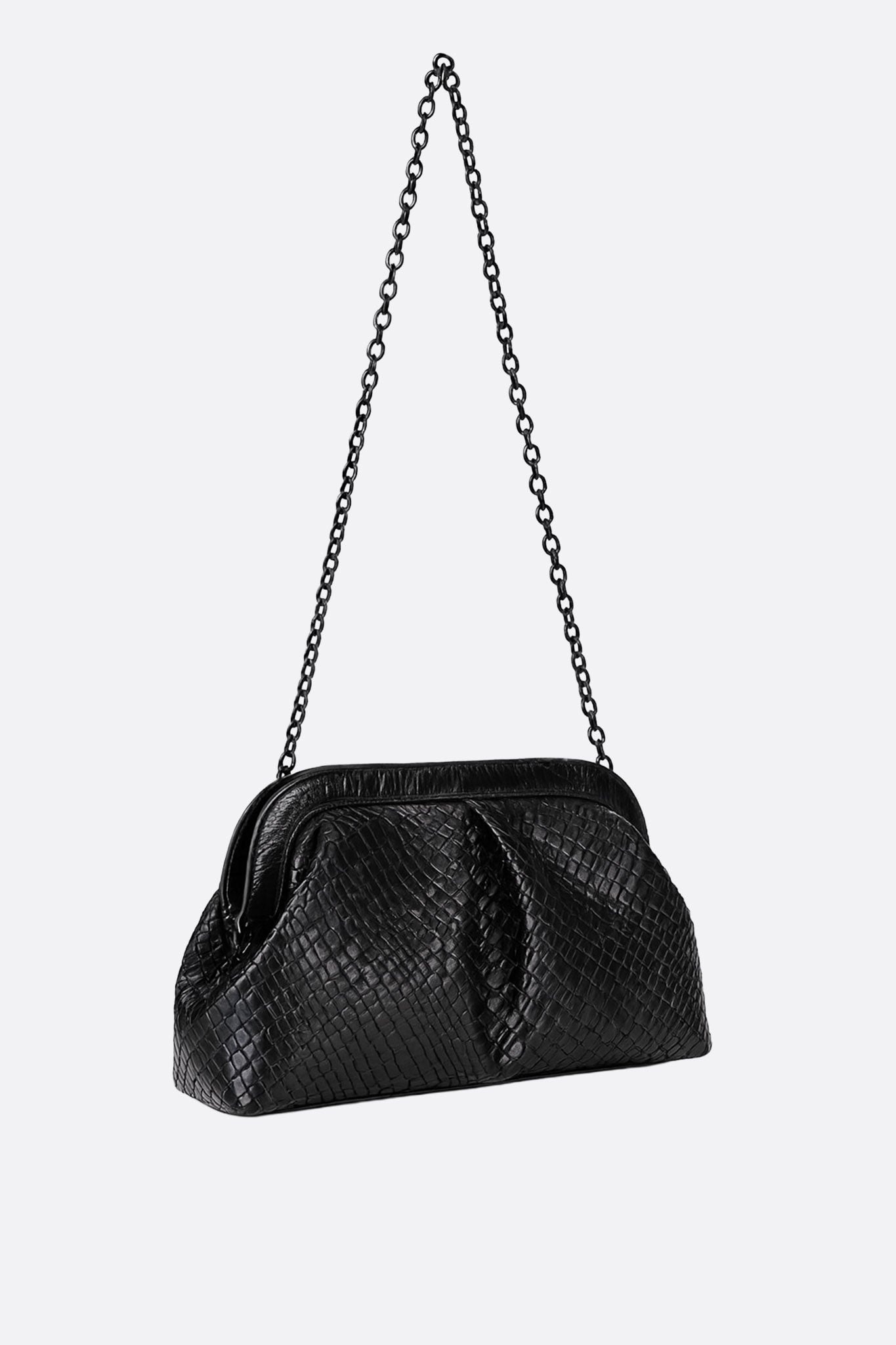 Détail de la pochette noire à texture tissée, accessoire raffiné pour une soirée chic et glamour.
