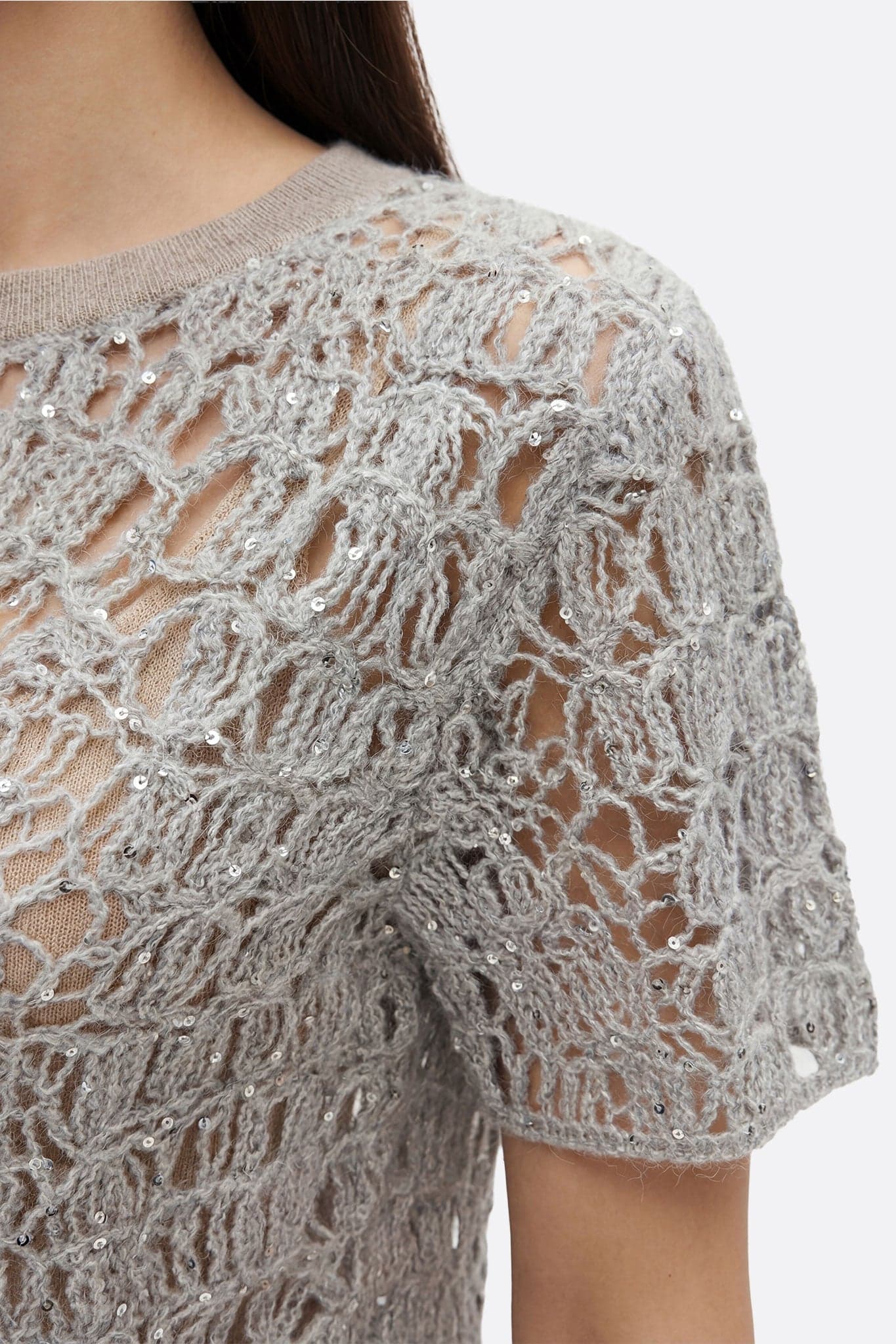 Dettaglio elegante del pull traforato grigio perla in mohair con lurex, perfetto per un look raffinato di giorno o di sera.