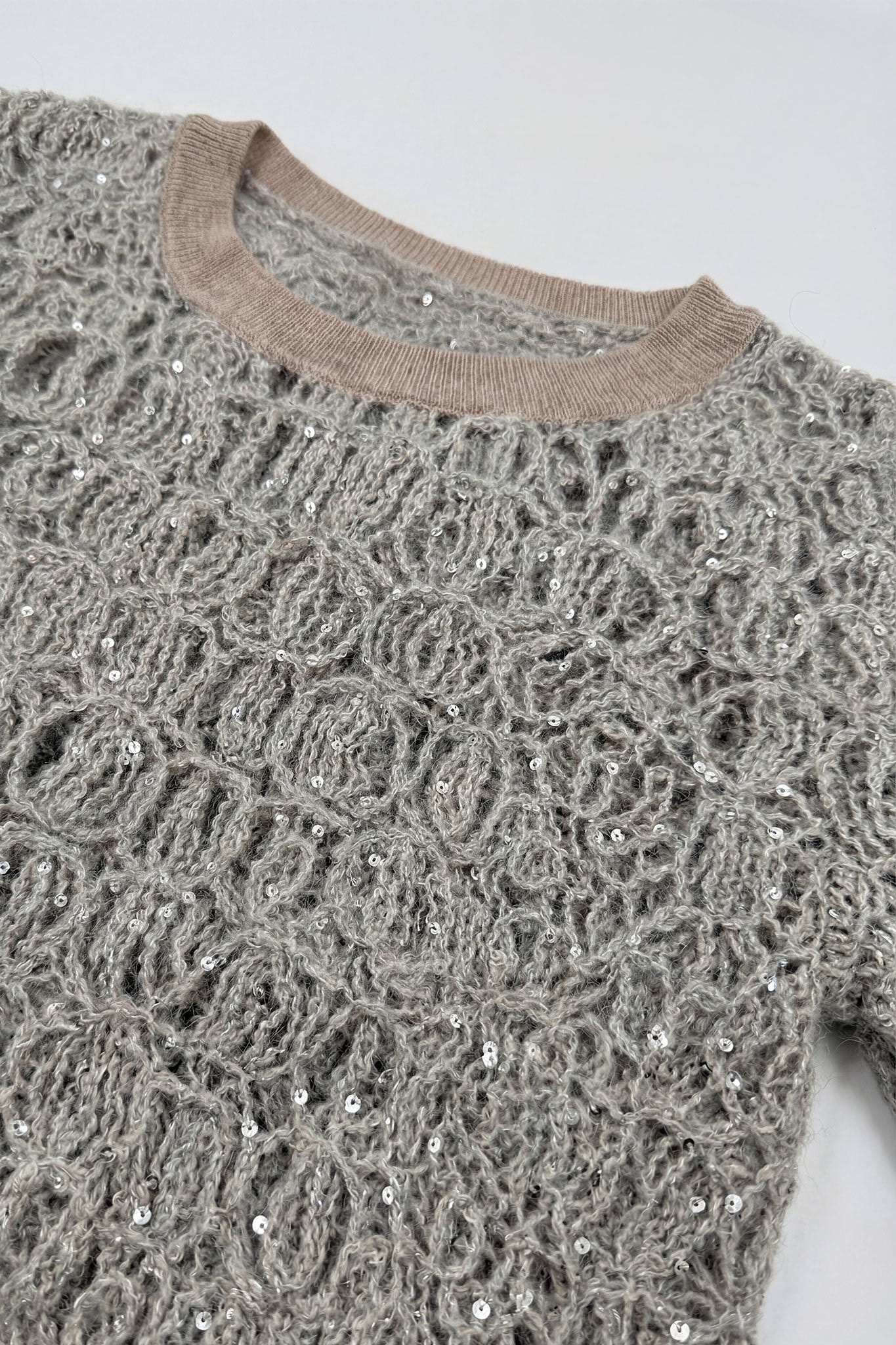 Detalles finos del jersey calado gris perla en punto de mohair y lurex, ideal para añadir un toque refinado a tu estilo.