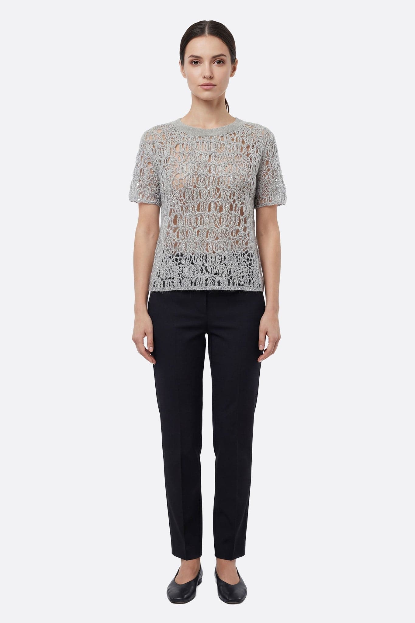 Dettaglio accattivante del pull in maglia traforata grigio perla con lurex, un pezzo chic per valorizzare un outfit estivo.