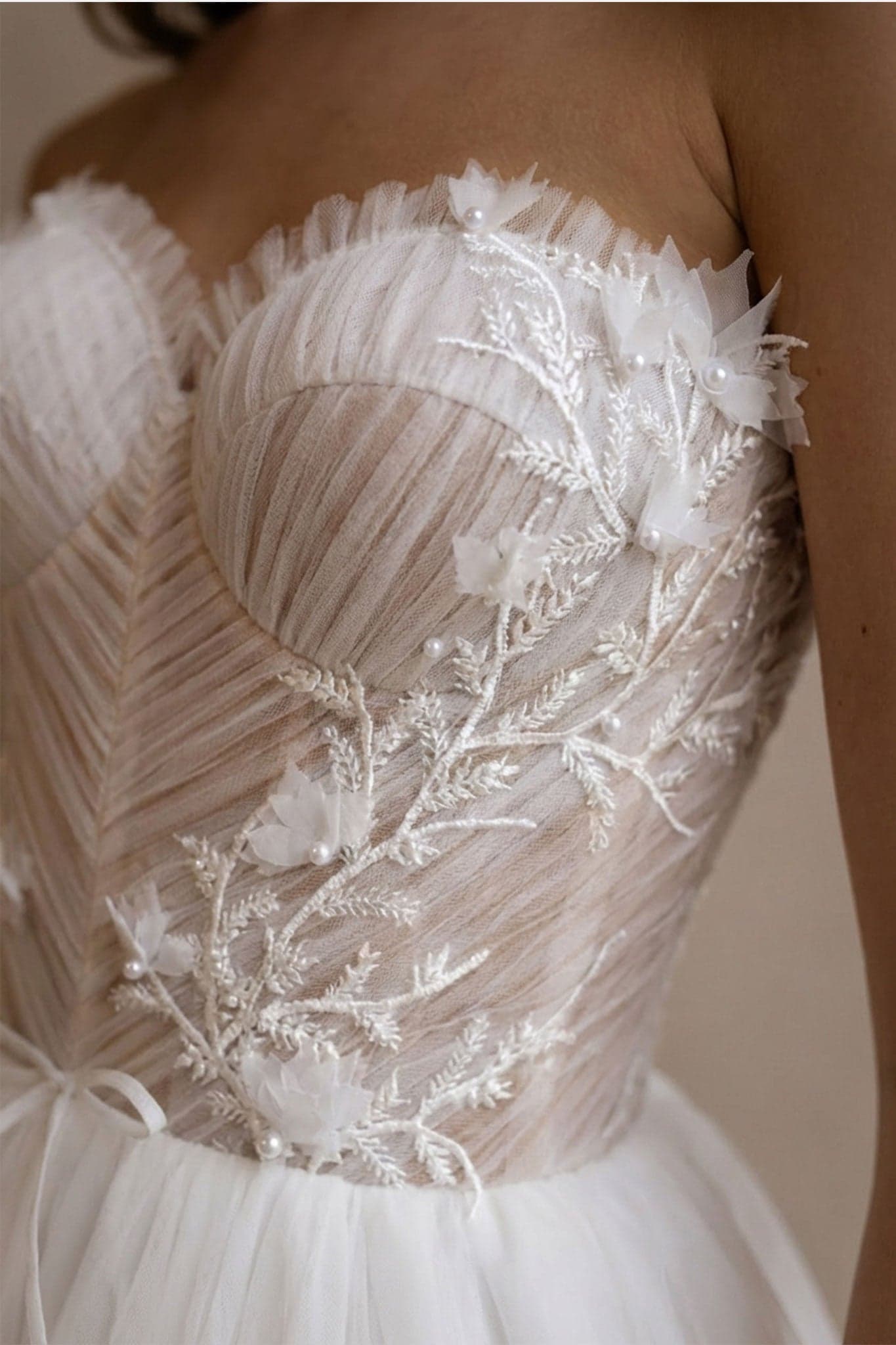 Detail of the Alena wedding dress in white tulle, highlighting the bustier and overcoat for a romantic allure.