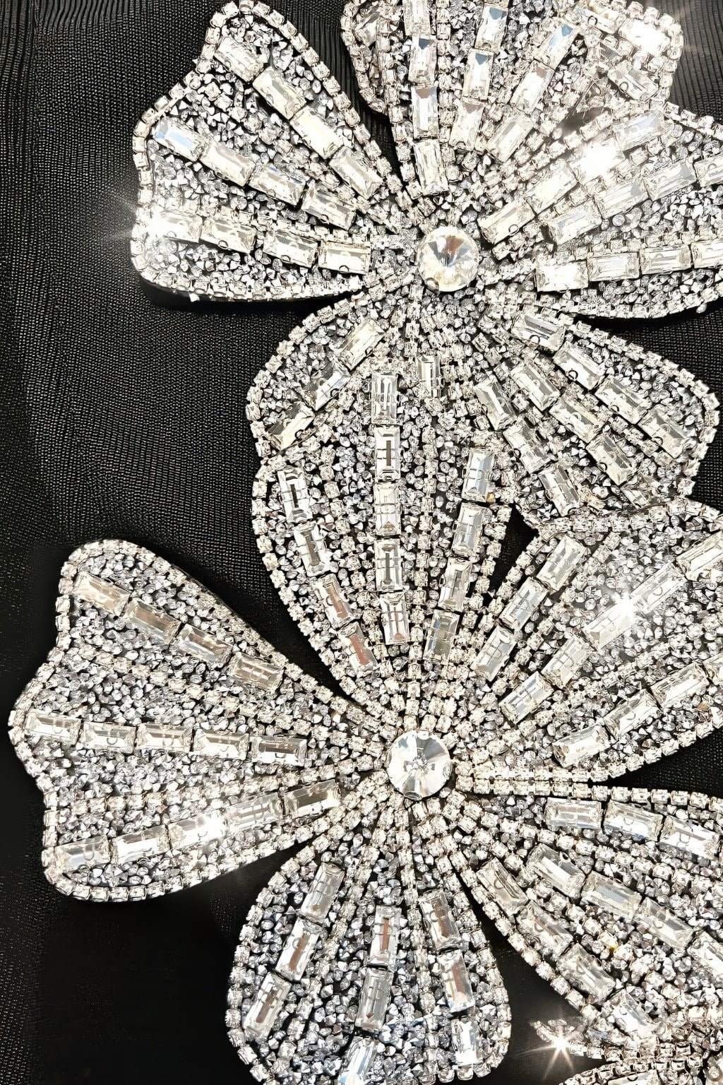 Détail de la robe sirène noire avec broderies brillantes, soulignant son design asymétrique pour une soirée chic.