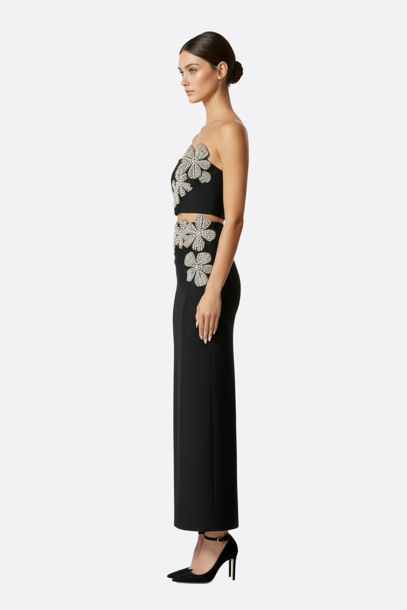 Robe asymétrique noire avec détails scintillants, idéale pour un événement glamour, mettant en valeur la silhouette féminine.