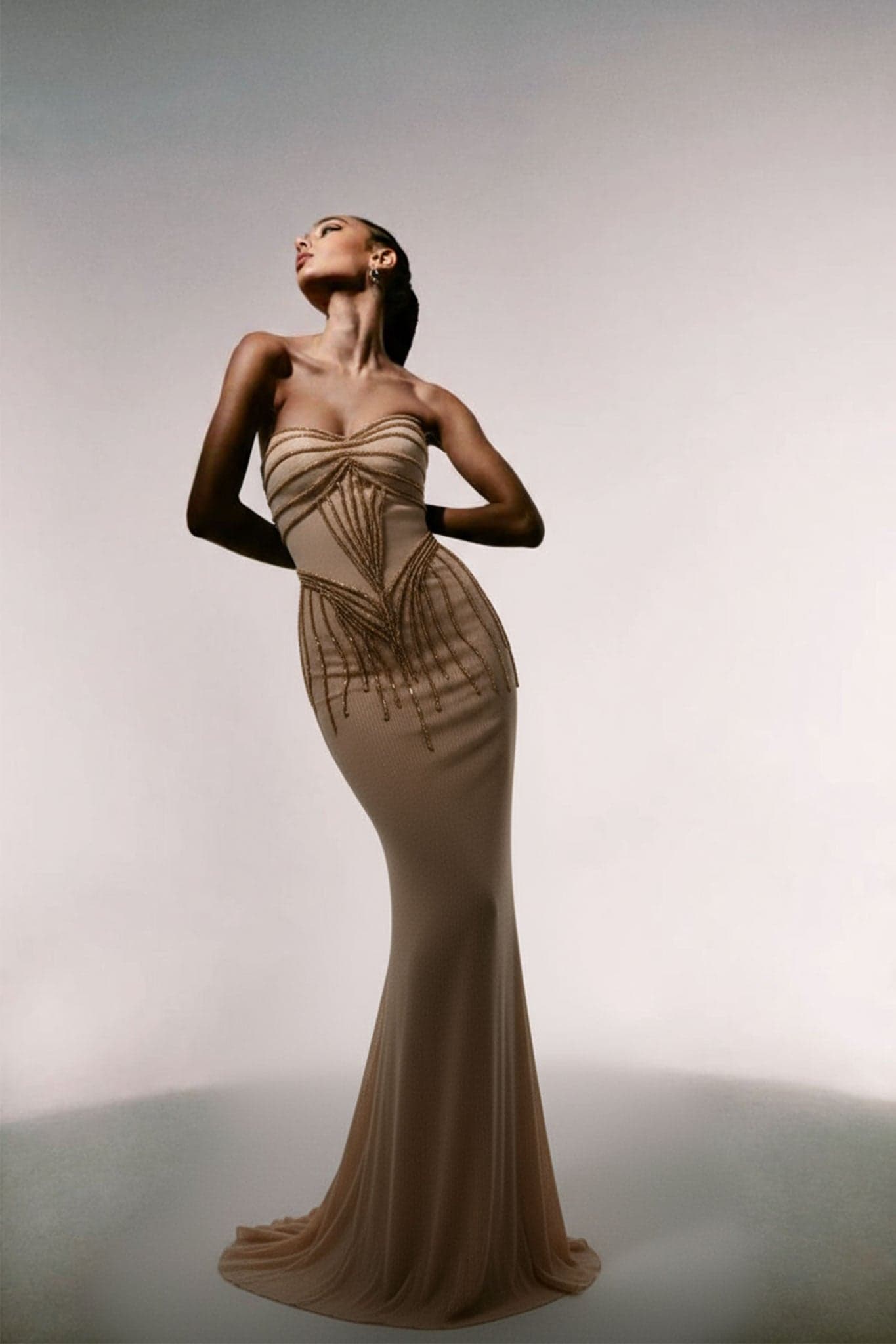 Robe longue sirène nude élégante, vue latérale mettant en valeur les broderies raffinées et la coupe flatteuse pour soirées.