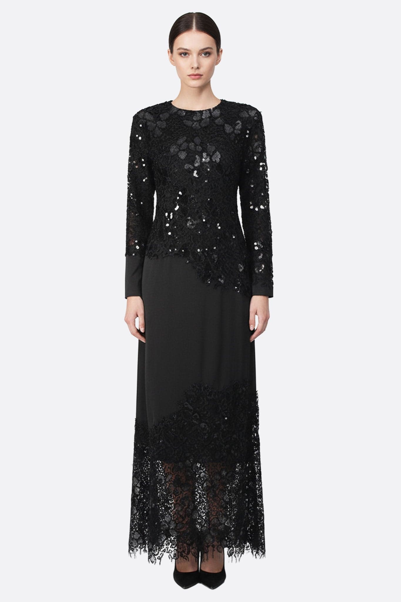 Robe longue noire ornée de dentelle et sequins, mettant en avant des manches longues, parfaite pour une occasion élégante.