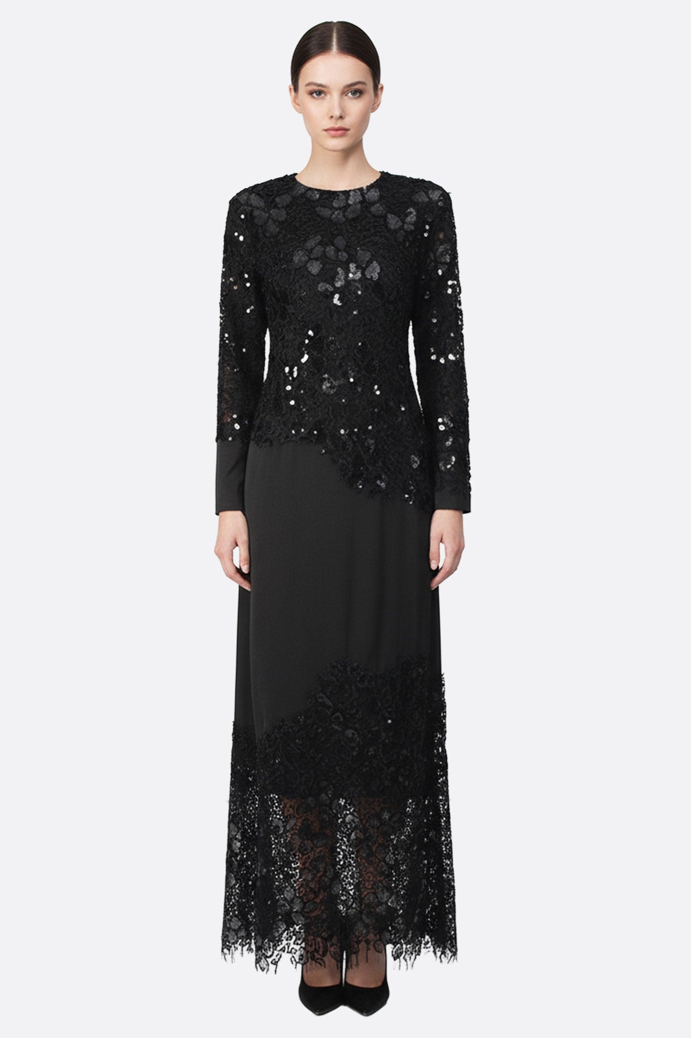 Robe longue noire ornée de dentelle et sequins, mettant en avant des manches longues, parfaite pour une occasion élégante.