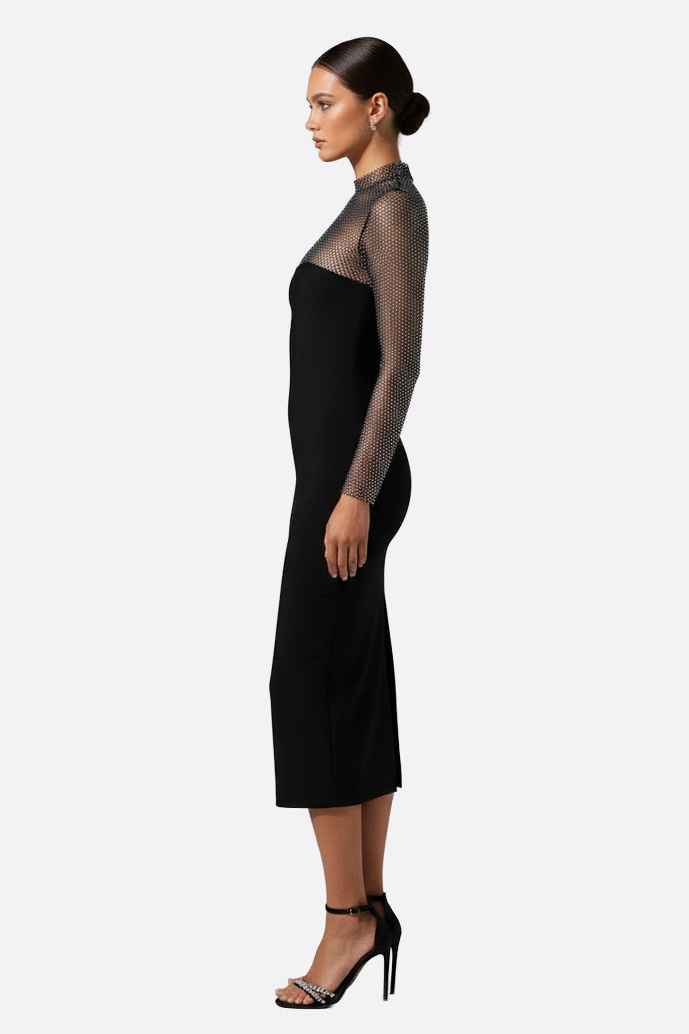 Détail de la robe noire à long tissu, mettant en valeur le haut en résille transparente pour une allure raffinée.