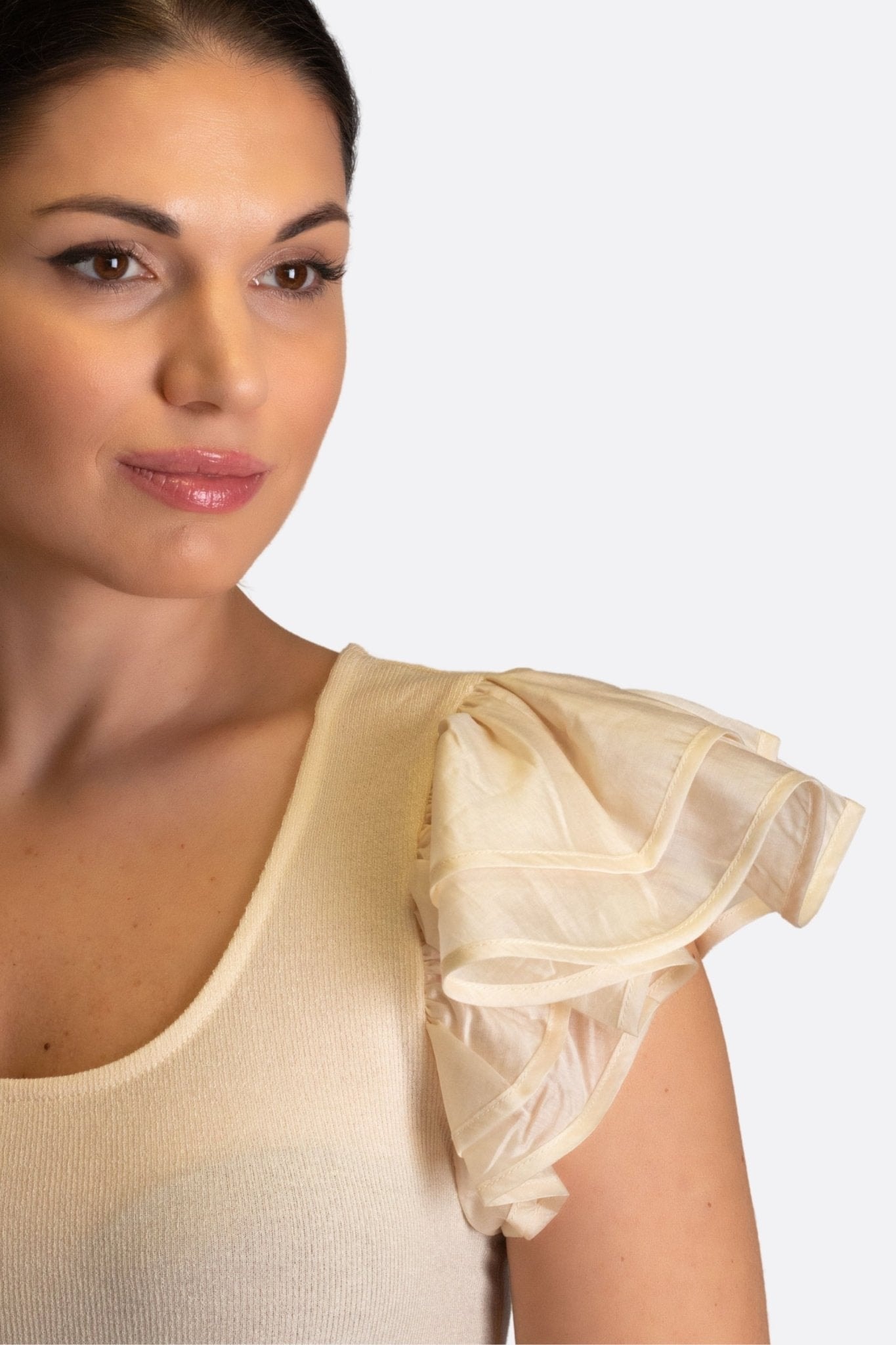 Détail des manches volantées en mousseline beige d'un top chic, idéal pour des occasions raffinées ou un style quotidien...