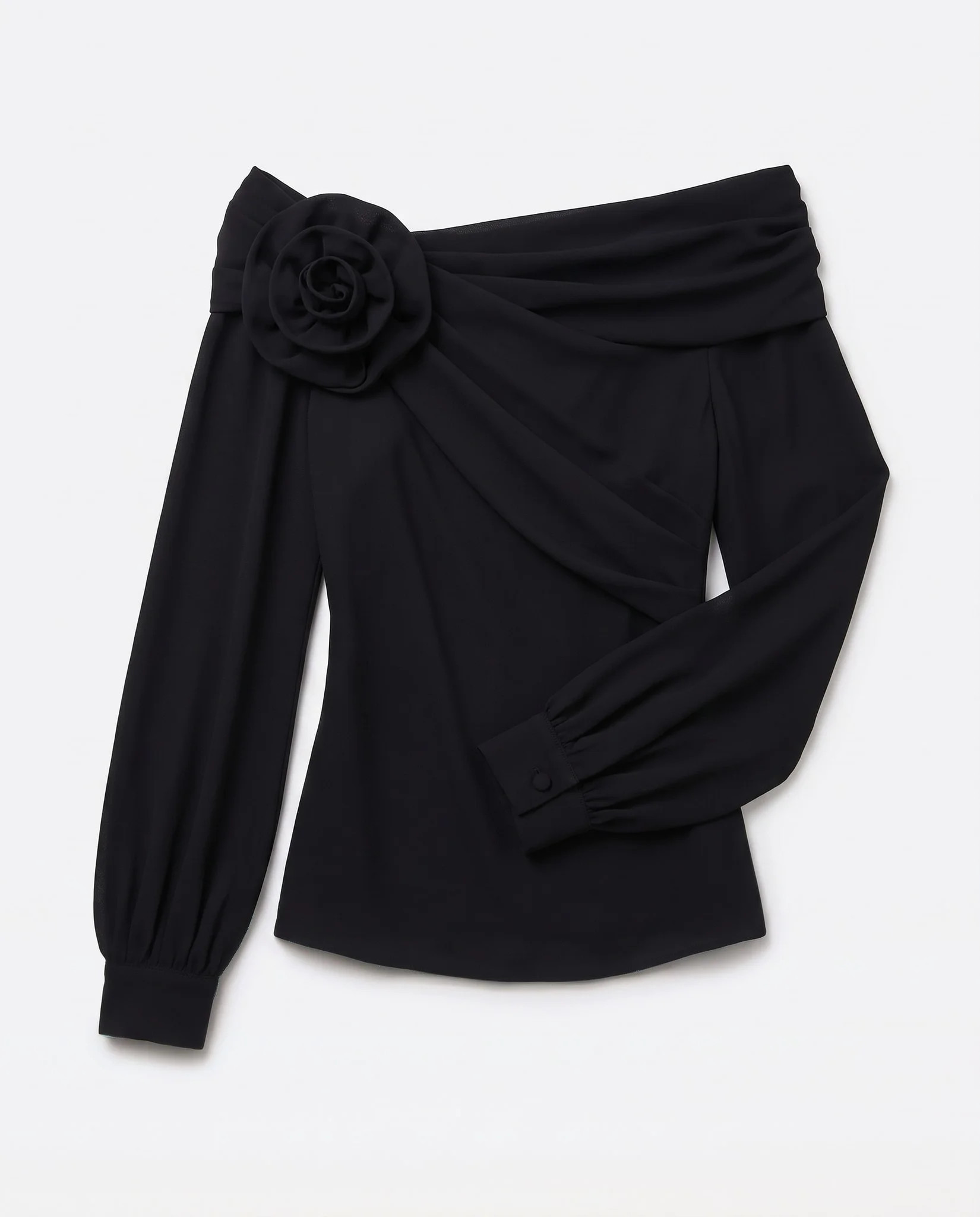 Top asymétrique noir à plat sur fond studio, crêpe opaque et poignet boutonné